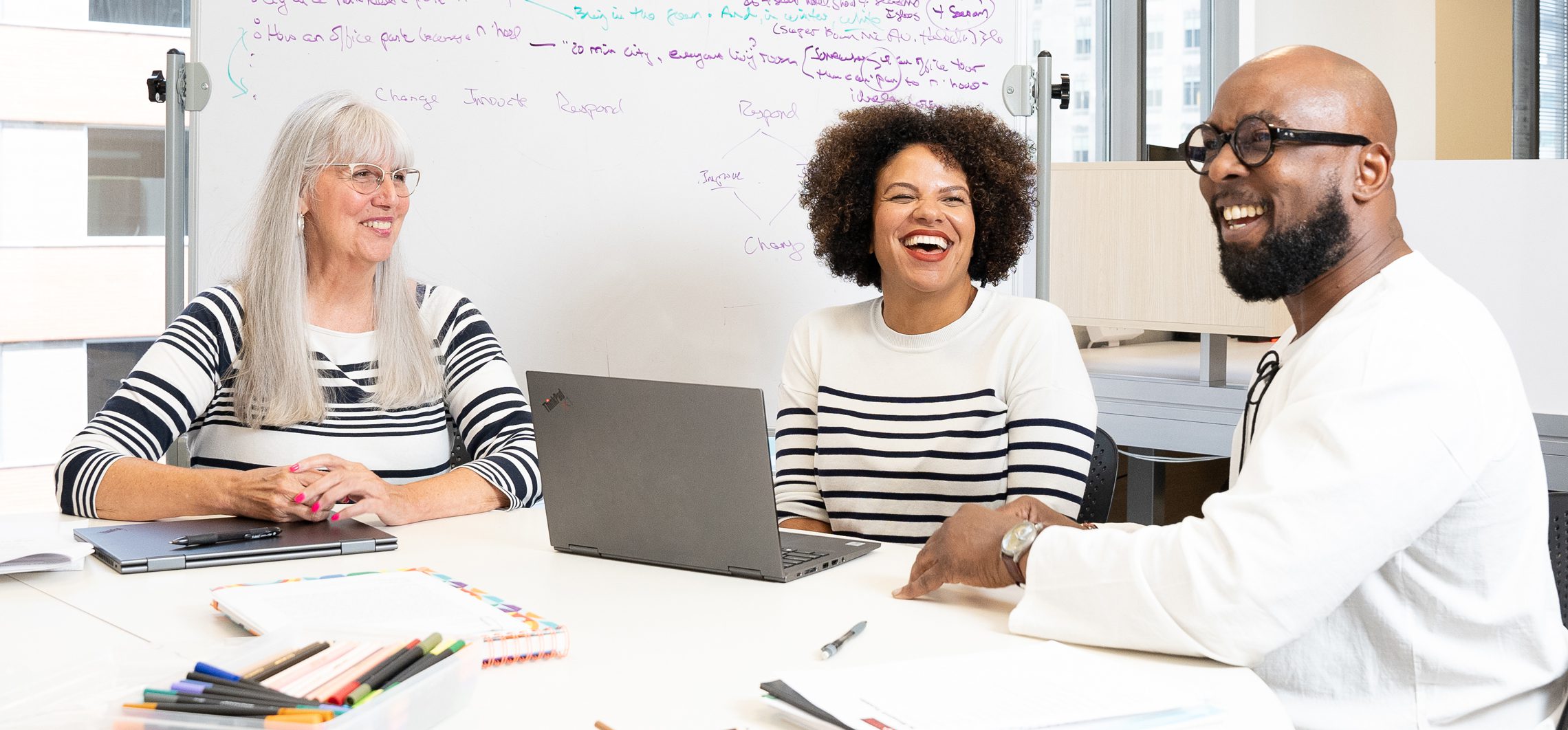 three minneapolis foundation staff laughing together at a table